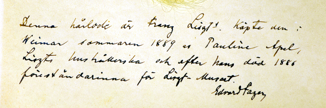 Edvard Fazers anteckning: Denna hårlock är Franz Liszts. Köpte den i Weimar sommaren 1889 av Pauline Apel, Liszts hushållerska och efter hans död 1886 föreståndarinna för Liszt-Museet.